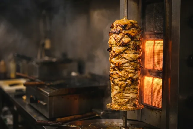Lo spiedo verticale con la carne kebab che gira davanti alla resistenza incandescente